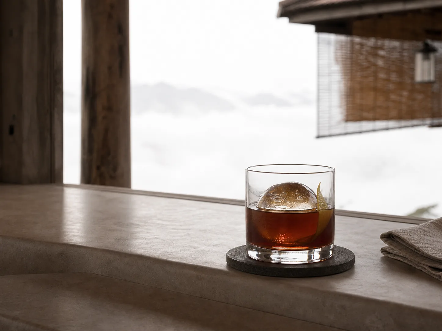 A dark cold brew over a single hand-cut ice sphere in a heavy glass